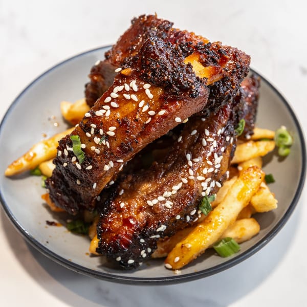 Sweet and spicy ribs with sesame seeds and green onions, served with golden french fries.